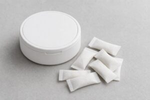 Generic nicotine pouch tin with pouches on a gray surface